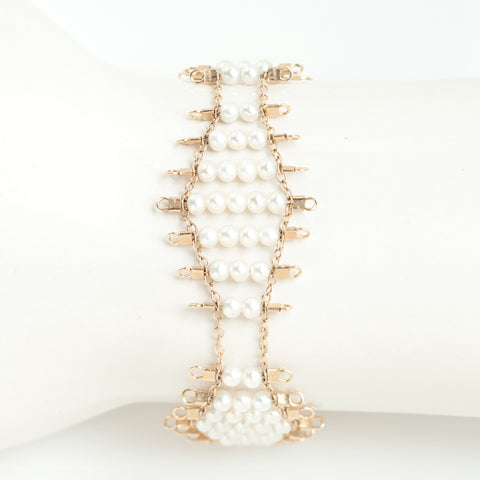 Kellan bracelet, featuring undulating rows of lustrous, white pearls, suspended on rows of 14k gold-fill wire and chain, and finished with a lobster clasp.  Approximately 7 inches in length.  
