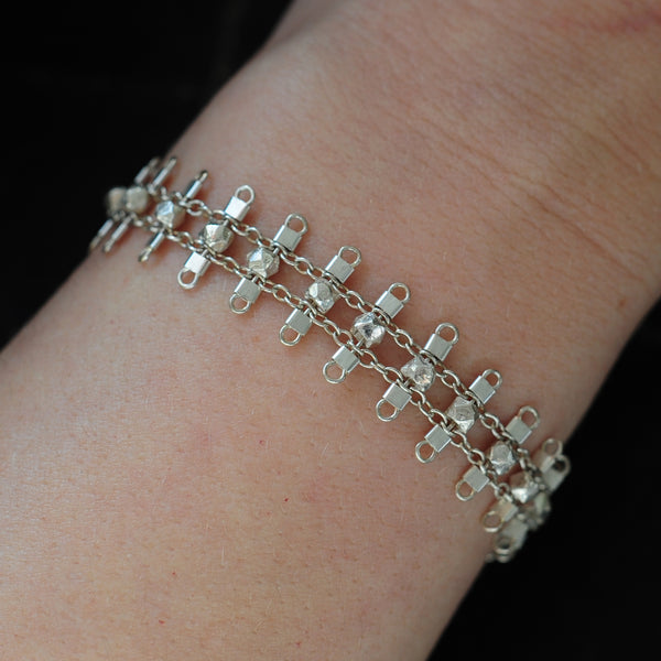 Artemis bracelet, featuring faceted, sterling silver beads suspended on sterling rungs and chain, finished with a lobster clasp.  Approximately 7 inches in length.
