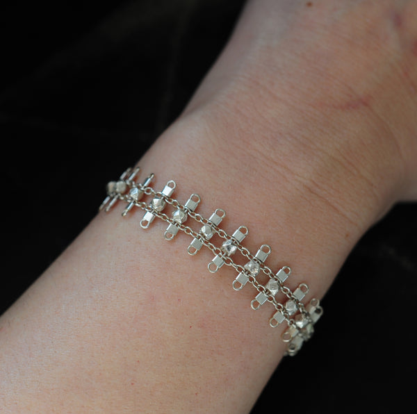 Artemis bracelet, featuring faceted, sterling silver beads suspended on sterling rungs and chain, finished with a lobster clasp.  Approximately 7 inches in length.