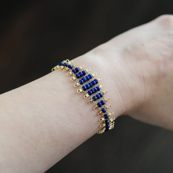 Juda bracelet, featuring faceted, navy blue, lapis lazuli beads suspended on 14k gold-fill wire and chain, finished with a lobster clasp.  Approximately 7 inches in length.